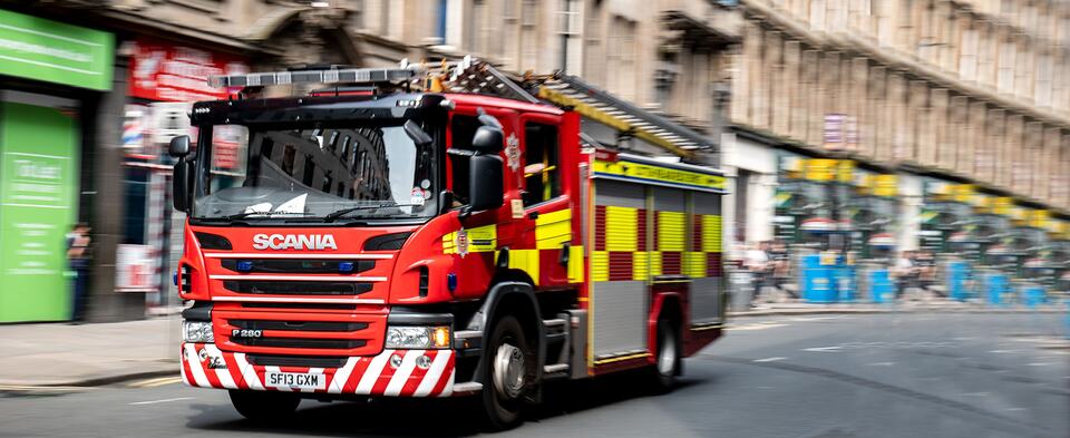 A red fire engine driving along a city street